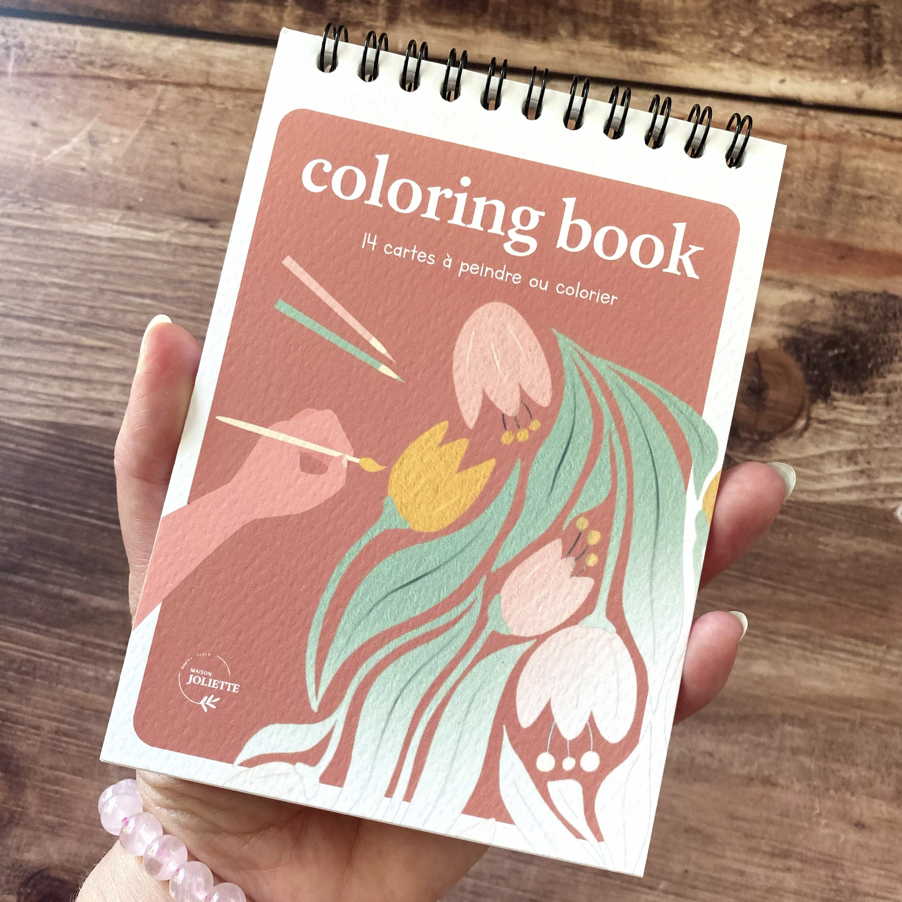 cahier de coloriage Floral tenu en main